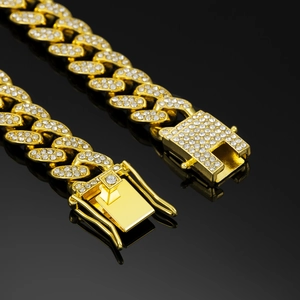 Macro view of iced out gold cuban link necklace with premium safety clasp closure