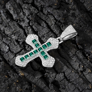 Detail showing the emerald-cut green crystal cross pendant with cubic zirconia micro-pave
