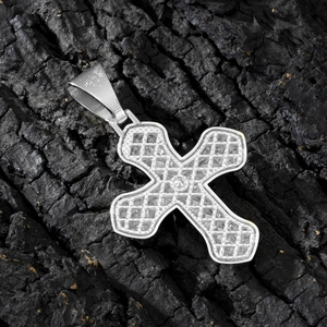 Macro shot of silver hollow-out cross pendant with sparkling zircons on black wood