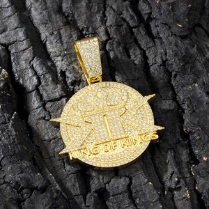 Macro shot of gold-plated King of Kings hip-hop pendant with iced out rhinestones