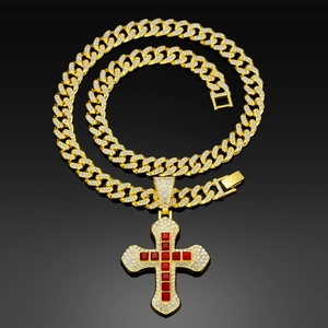 Macro detail of gold Cuban link chain with a zircon encrusted cross and red square stones