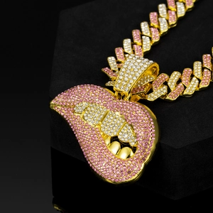 Macro-opname van een roze strass hart hanger aan een gouden cuban chain met AOD letters