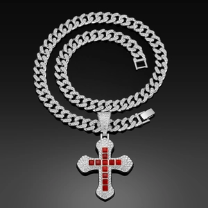 Macro shot of hip hop cross pendant with red square gems and iced-out cuban chain