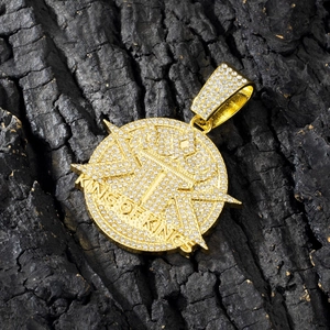 Macro shot of gold hip-hop pendant with King of Kings text and crystal pavé stones