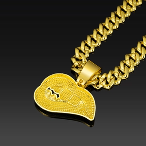 Macro-opname van een gouden Cubaanse schakelketting met een getextureerde hart hanger