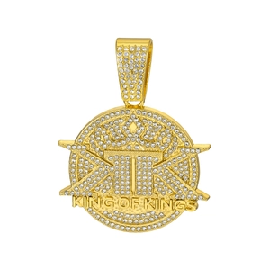 Detailed view of gold King of Kings hip hop pendant with white iced-out zircons