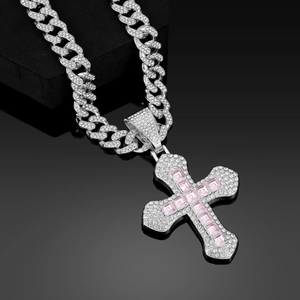 Detail of silver cuban chain necklace with large cross pendant and pink square stones