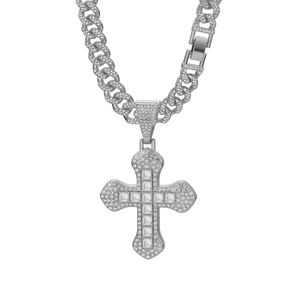 Macro detail of iced-out silver cross pendant with square-cut stones on Cuban link chain