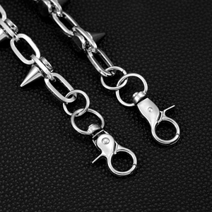 Nahaufnahme der Punk-Metallkette mit silbernen Nieten auf schwarzem Lederhintergrund