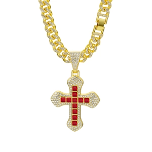 Detail of hip hop gold cross pendant with red and white stones on cuban link chain