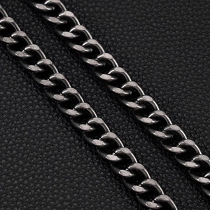 Detailed macro view of dark gunmetal Cuban curb chain on black leather background