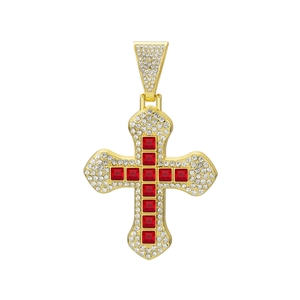 Macro detail of gold cross pendant with red square zircon stones and white crystal inlay