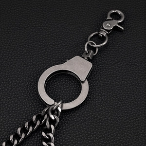 Close-up of hip hop pant chain featuring vintage silver metal handcuffs on black leather