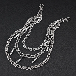 Close-up of triple-layered silver metal pant chain with bullet pendants on leather background