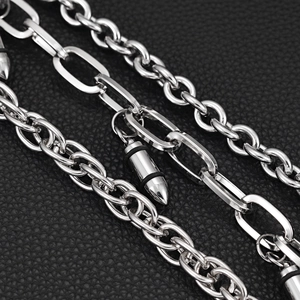 Macro detail of triple-layered silver chains with bullet pendants on leather