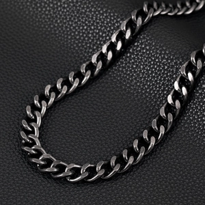 Close-up of gunmetal skull wallet chain with heavy curb links on black leather texture