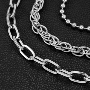Macro view of triple layered silver hip hop chains with flat and textured links