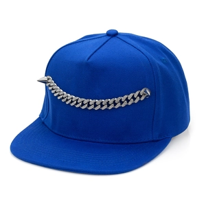 Close-up of royal blue baseball cap with silver cuban chain and punk metal spikes