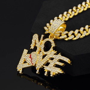 Détail du pendentif NO LOVE hip hop avec chaîne à maillons cubains dorée glacée