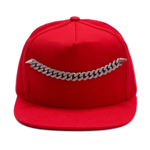 Detail of red snapback hat featuring a silver rhinestone chain and punk metal spikes