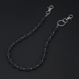 Detail of matte black skull beads on a punk style wallet chain with silver metal clasps