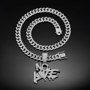 Détail du pendentif cœur NO LOVE argenté serti de zircons sur une chaîne à mailles cubaines