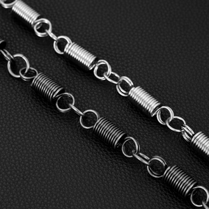 Detailed macro view of silver and gunmetal punk style metal pant chains on black leather