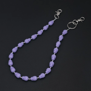 Detail of purple skull beaded trousers chain with matte finish and metal lobster clasps