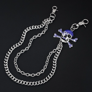 Detail of silver skull pendant with blue rhinestones on double punk style waist chain