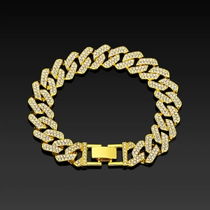 Close-up of golden Cuban link bracelet with iced-out rhinestones on black reflection