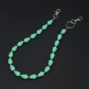 Detail of light green skull bead chain with silver metal hardware on leather