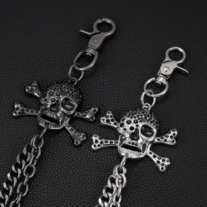 Detailed close-up of punk skull and crossbones waist chains with black rhinestones