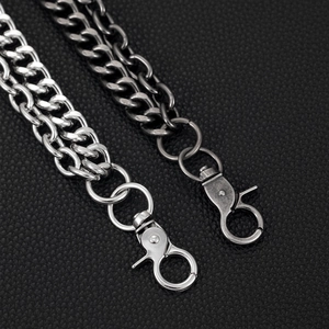 Detail showing punk skull pants chains in silver and gun-black on black leather