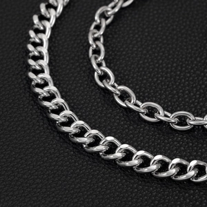 Macro shot of polished silver metal curb chain link on black leather background