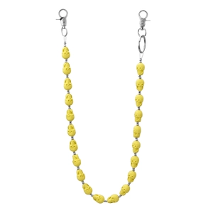 Detail view of yellow matte skull keychain with dual silver lobster clasps for jeans