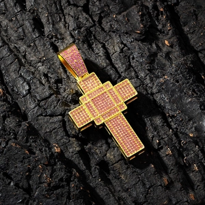Makro-Detail von vergoldetem Kreuzanhänger mit rosa Pavé-Strasssteinen