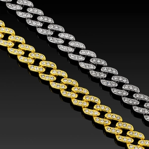 Macro detail van de 12mm Cubaanse schakelketting in goud en zilver met glanzende strass