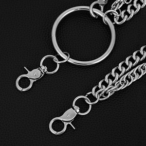 Detail of silver metal double-layer pants chain with snap hooks on leather background