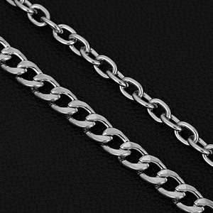 Macro shot of silver punk metal Cuban and cable link chains on black leather