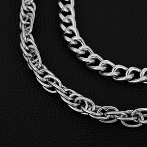 Macro detail of polished silver double-layered hip-hop metal chains on black leather background
