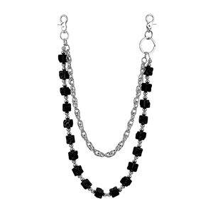 Detail of a multi-layer punk waist chain with silver metal links and black skull cubes