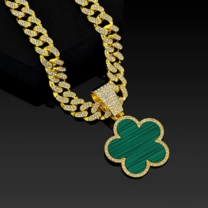 Detail view of gold Cuban link chain with iced out five-leaf clover malachite pendant