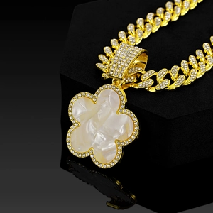 Detail of clover pendant with mother of pearl shell and crystals on gold cuban chain