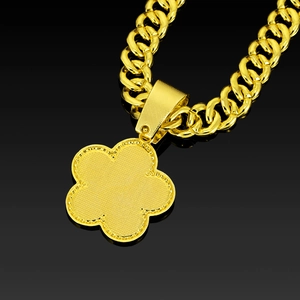 Macro shot of gold Cuban chain with matte grid texture detail on the flower pendant back