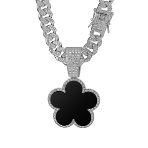 Detail of silver Cuban chain necklace with iced out black flower clover pendant
