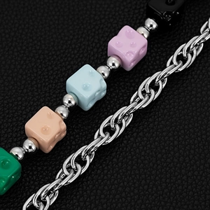 Close-up of hip-hop waist chain with colorful dice beads and silver link chain on leather
