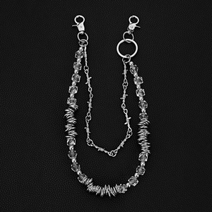 Detail of silver double-layered trousers chain with clear square beads and metallic spikes