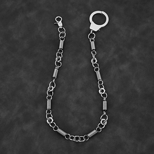 Industrial punk metal pants chain with nut charms and handcuff ring on leather surface