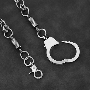 Industrial punk metal pants chain with handcuffs and screw nuts on leather background