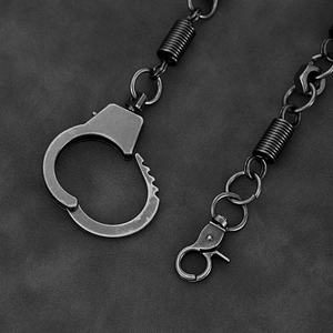 Macro shot of industrial pants chain with mini handcuffs, spring coils, and hex nuts